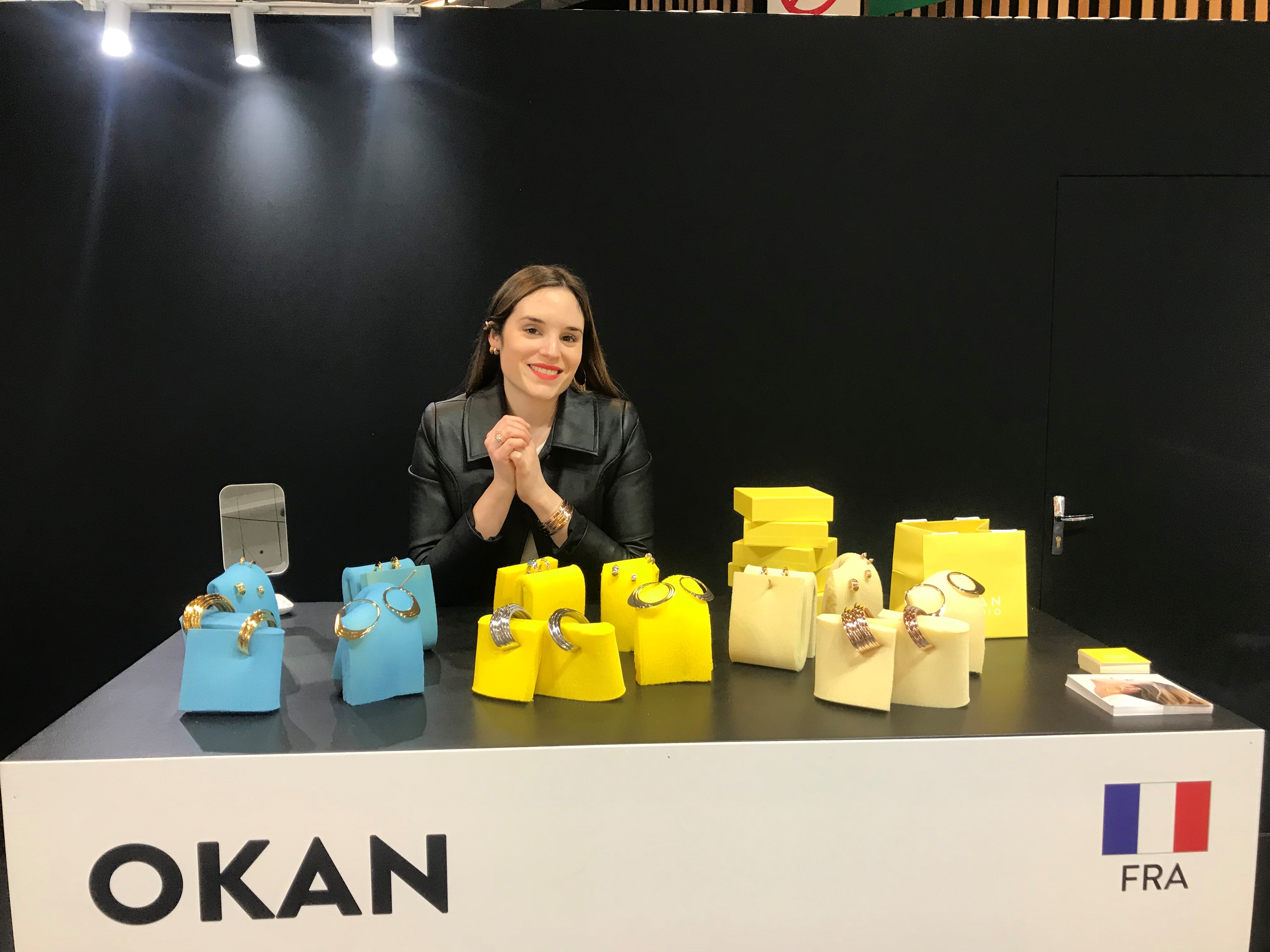 créatrice de la marque Okan derrière son stand Challangel au salon Bijorhca paris