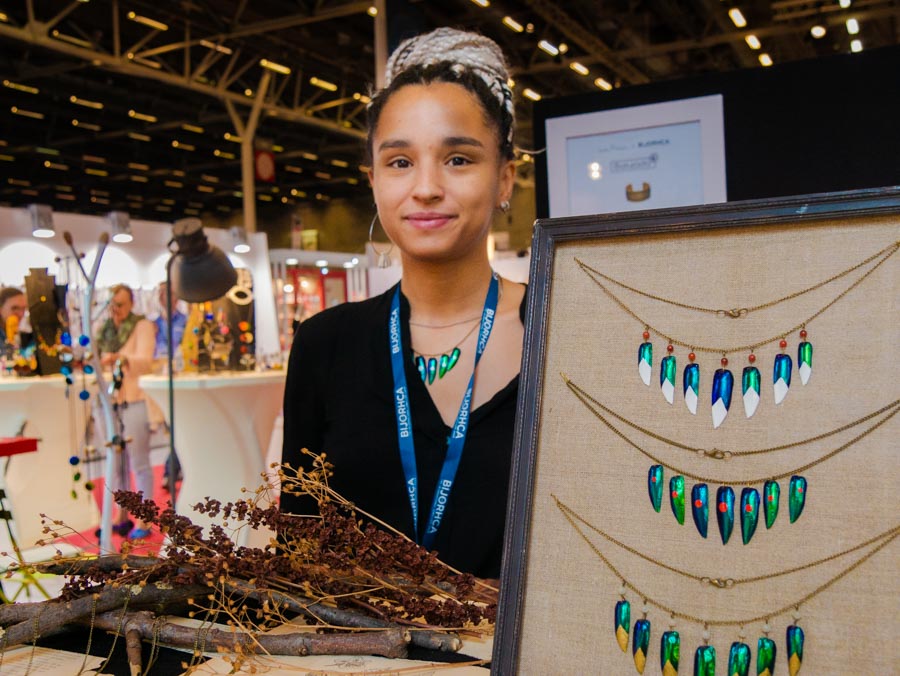 La créatrice de bijoux Mami Tina pose devant son stand Bijorhca