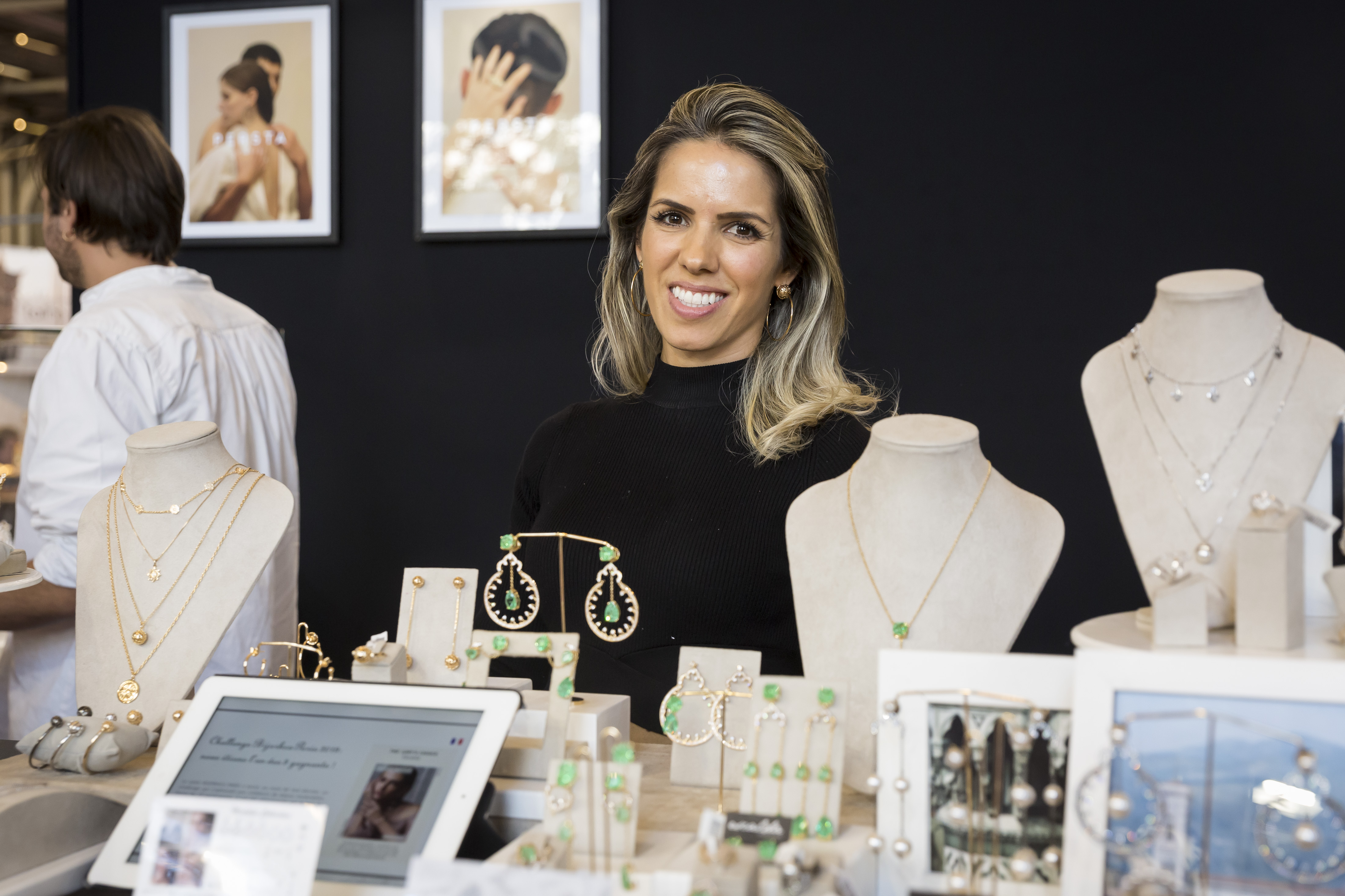 La créatrice des bijoux Escalda Design pose derrière son stand Bijorhca en souriant 